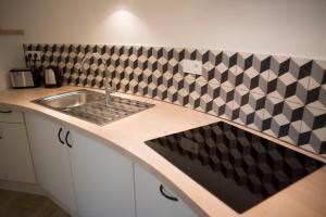 a kitchen with a sink and black and white tiles at Douce Nuits in Nuits-Saint-Georges