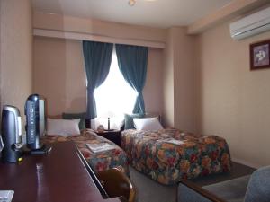 Tempat tidur dalam kamar di Asahi City Inn Hotel