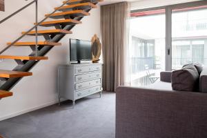 sala de estar con escalera, TV y sofá en Casas do Teatro, en Oporto
