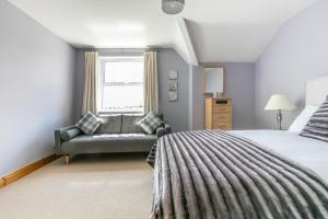 1 dormitorio con cama, sofá y ventana en Titanic View Luxury Apartment Belfast en Belfast