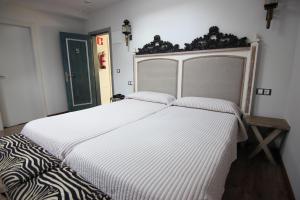 um quarto com uma grande cama branca num quarto em El Lacayo de Sestiello em Grado