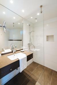 a bathroom with a sink and a shower at Hotel Susato in Soest