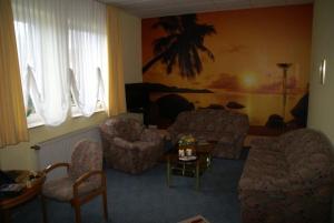 a living room with a couch and chairs and a table at Weser Wasserbetten Hotel Baxmann in Hessisch Oldendorf