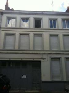 um edifício branco com muitas janelas em Treilles'Appart em Lille