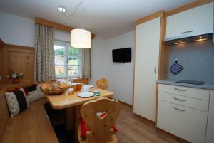 - une cuisine et une salle à manger avec une table et des chaises dans l'établissement Villgraterhof, à Sesto