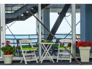 two chairs and a table on a balcony with flowers at IDRO Studio Apartments directly at the beach in Split