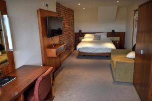 a bedroom with a bed and a tv and a couch at The Wharf Stourport in Stourport