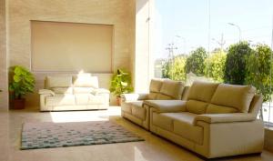a living room with two couches and a large window at Hotel Grand Maple in Jaipur