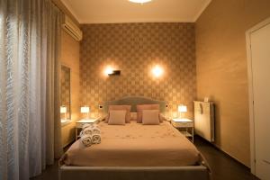 Un dormitorio con una cama grande con dos mesas y dos lámparas. en B&B Civico Cinque, en Salerno