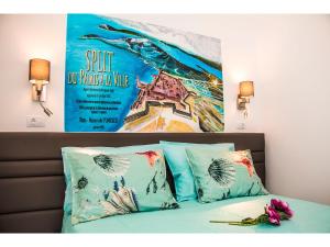 a poster on a wall above a bed with pillows at IDRO Studio Apartments directly at the beach in Split