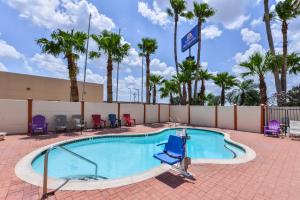 una grande piscina con sedie e palme di Express Inn Weslaco/Mercedes a Weslaco