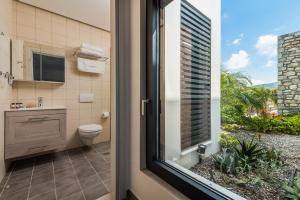 a bathroom with a toilet and a window at Prasonisi Villas in Kattavía