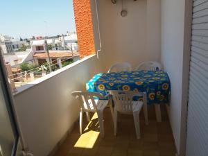 a small balcony with a table and chairs and a window at Monolocali Angelica in Porto Cesareo