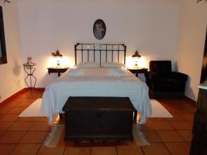 ヴィラ・ノヴァ・デ・ミルフォンテスにあるCasa das Hortências By Alojamentos Vitinho - Vila Nova MIlfontesのベッドルーム1室(ベッド1台、ランプ2つ、椅子付)