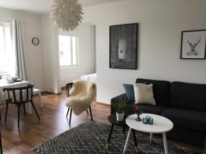 ein Wohnzimmer mit einem Sofa und einem Tisch in der Unterkunft Lapland Quality City Apartment Rovaniemi in Rovaniemi