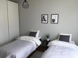 2 Betten in einem Zimmer mit weißen Wänden in der Unterkunft Lapland Quality City Apartment Rovaniemi in Rovaniemi