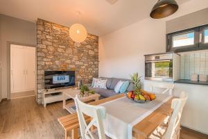 a living room with a table and a stone wall at Prasonisi Villas in Kattavía