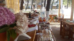 a table with some food and flowers on it at Aparthotel Vila Tufi in Velipojë