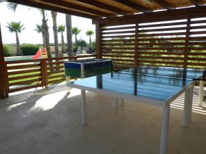 una mesa de ping pong en un patio con palmeras en Baglio Olivastro, en Digerbato