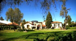 una casa en un césped verde con un árbol en Hacienda La Magdalena, en San Francisco Tesistán