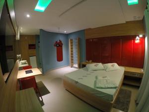 a bedroom with a bed and a bathroom with a fire hydrant at Happy Night (Adults Only) in Cotia