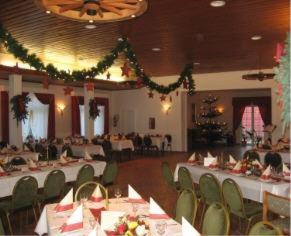 a banquet hall with white tables and green chairs at Neukirchener Hof in Malente