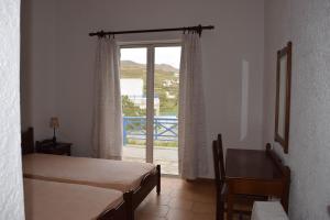 a room with two beds and a window with a view at House near Sea in Gavrio
