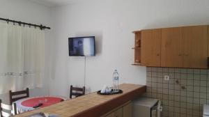 cocina con encimera y TV en la pared en House near Sea, en Gavrion