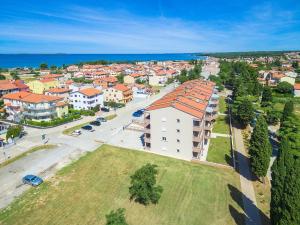 eine Luftansicht einer Stadt mit Gebäuden und dem Meer in der Unterkunft Adriatic Apartments in Fažana