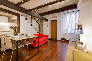 a living room with a red couch and a table at Rome as you feel - Chiavari 38 Apartment in Rome