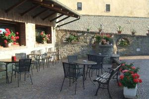 Albaretto Della Torre にあるAlbergo Dei Bersaglieriの屋外パティオ(テーブル、椅子、花付)