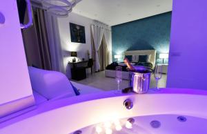 a purple bathroom with a sink and a living room at Maschio Angioino Suite in Naples