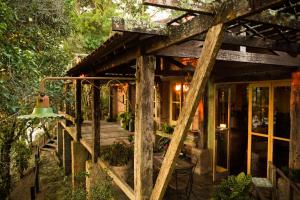 Cette maison en bois dispose d'une terrasse couverte. dans l'établissement Pousada Janela do Céu, à Conceição da Ibitipoca