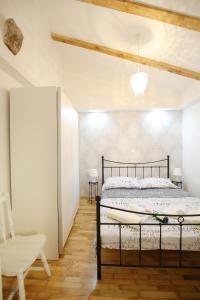 a bedroom with a bed and a chair at Apartments Grisogono in Zadar +19 photos