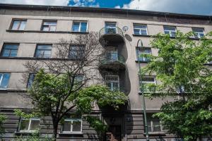 an apartment building with a balcony and trees at 3D Royal Castle Apartament in Krakow