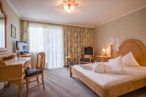 a bedroom with a bed and a desk and a computer at Hotel Achentalerhof in Achenkirch +132 photos