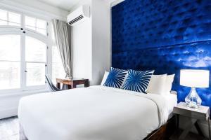 a bedroom with a large bed with a blue wall at C3- Hotel Art De Vivre in Quebec City