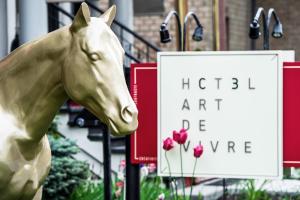 eine Statue eines Pferdes vor einem Schild in der Unterkunft C3- Hotel Art De Vivre in Québec