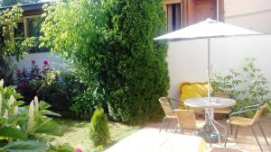 a patio with a table and chairs and an umbrella at Penzion Rose in Štúrovo