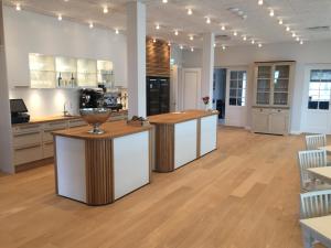 a large kitchen with white cabinets and wooden counter tops at Hotel Bretagne in Hornbæk