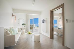 a white living room with a couch and a table at Infinity Blu - Designed for Adults by Louis Hotels in Protaras +40 photos