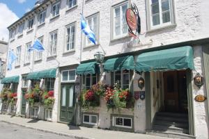 a building with flowers in front of it on a street at Hotel Acadia in Quebec City