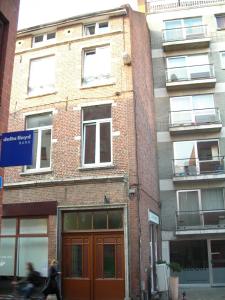 un bâtiment situé dans une rue où une personne passe à pied dans l'établissement Huize Rafael, à Louvain