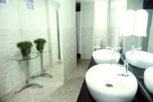 a bathroom with two sinks and a mirror at Planalto Bittar Hotel e Eventos in Brasília