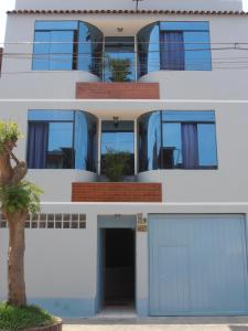 a white building with blue doors and windows at Septima Maravilla in Lima