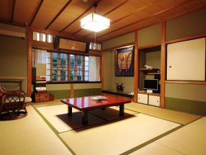 a living room with a table in the middle of it at Koyasan Onsen Fukuchiin in Koyasan