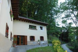 a house with chairs and a table in front of it at Albergue Casa Txakainlo in Lesaka