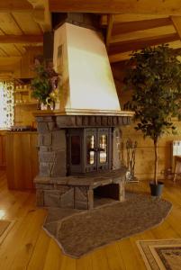 a stone stove in a room with a tree at Szałas u Eweliny in Kościelisko