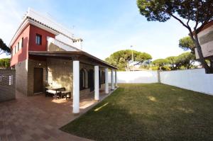 a patio of a house with a grass yard at Chalet Nora in Chiclana de la Frontera