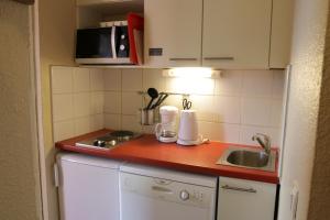 eine kleine Küche mit Spüle und Arbeitsplatte in der Unterkunft Résidence Les Bergers in L'Alpe-d'Huez + 16 Fotos